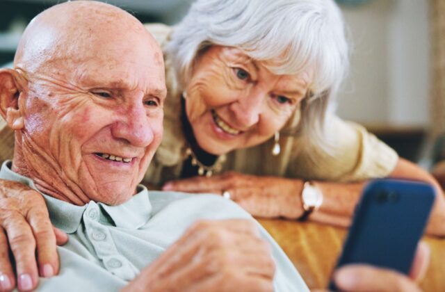 A senior couple playing a smartphone game together.