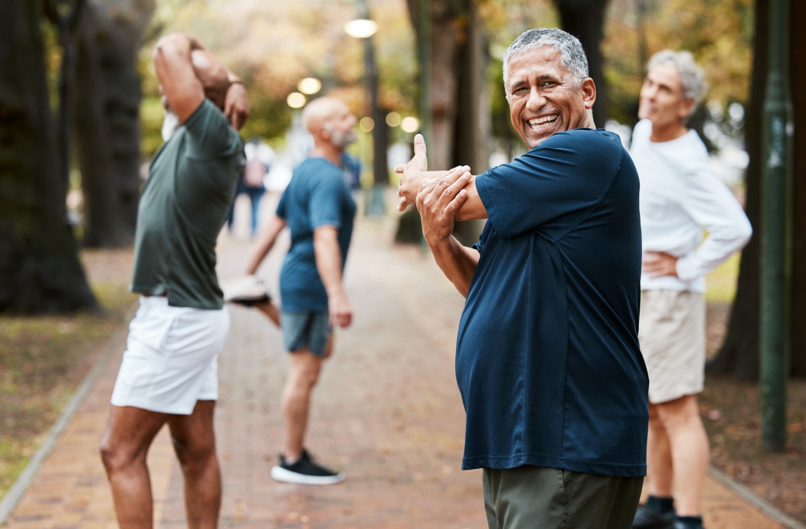 Seniors performing outdoor stretches as part of a cardio workout, promoting physical fitness and flexibility for healthy aging.