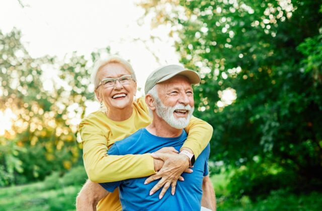 Senior couple walking together in a park, enjoying a cardio workout routine that supports cardiovascular health and active living.