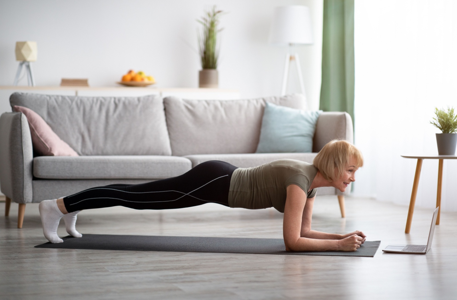 An older woman holding the plank position to support her core health.