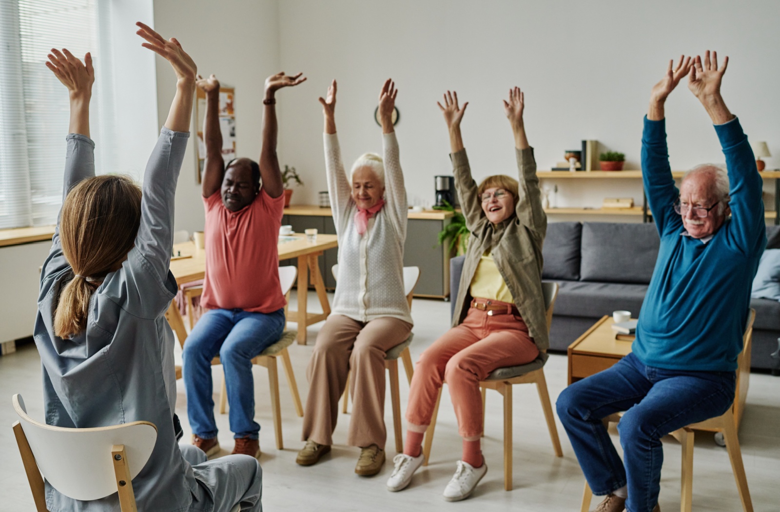 A group of older adults in their chair fitness class to promote overall strength.